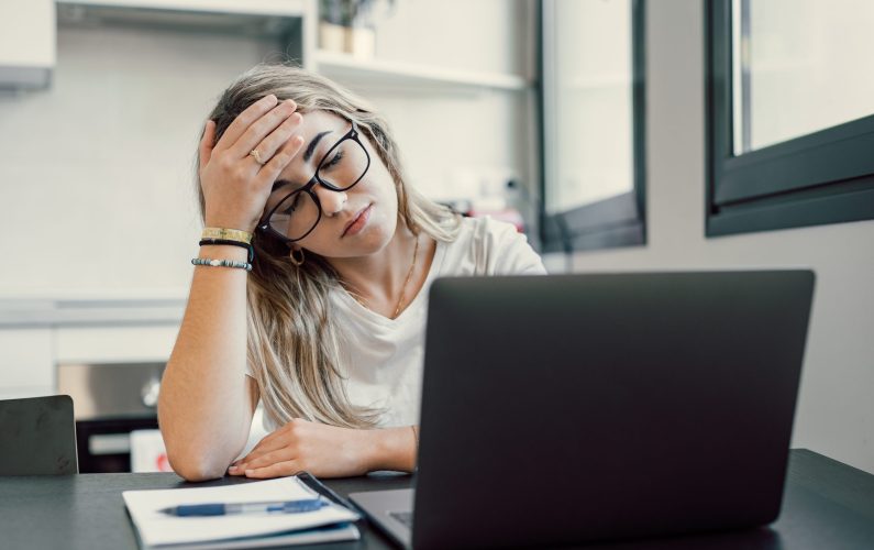 Stressed tired woman in pain having strong terrible headache attack after computer laptop study, fatigued exhausted girl suffering from chronic migraine massaging temples to relieve head ache tension