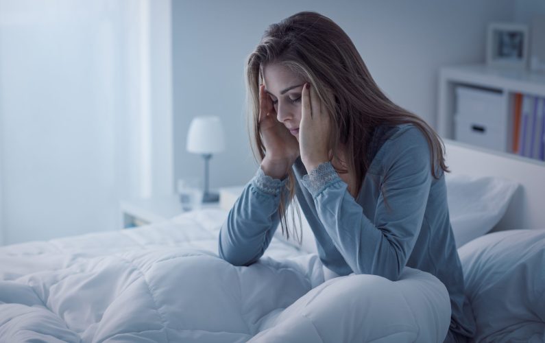 Depressed woman awake in the night, she is exhausted and suffering from insomnia