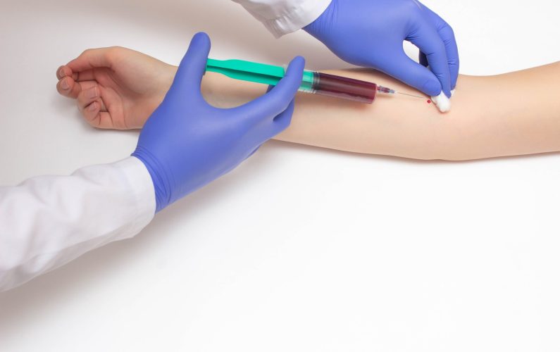 A doctor takes a biochemical blood test from a patient's vein for a blood test