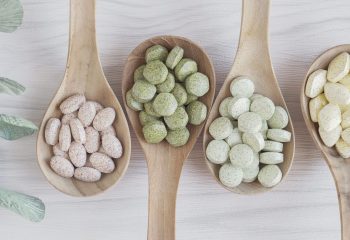 Natural cruciferous vegetables and alternative herbal tablet pills in wooden spoons, keto diet dietary supplements for healthy gut